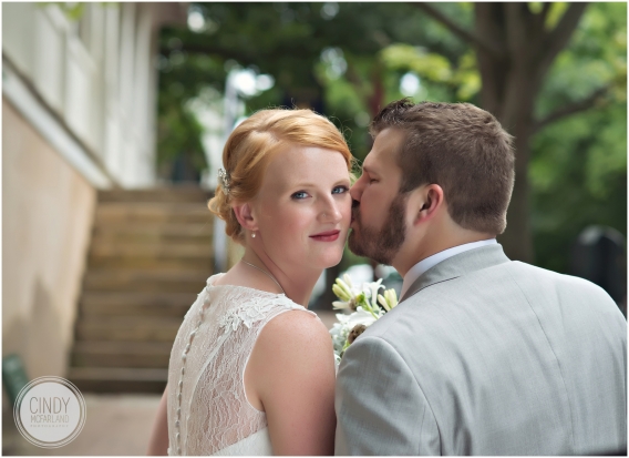 Close up of groom kissing bride on the cheek