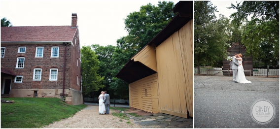 Bride and groom walking past yellow barn at Old Salem